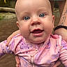 Esmae joined the competition — help win amazing prizes! baby, infant, child, portrait, close_up, smiling, wide_eyed, pink_outfit, patterned_clothing, outdoors, adult, hands, support, face, eyes, head, sitting, photography, happy, adorable