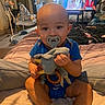 Kasey is registered to the contest to win money with this photo: baby, bed, bedroom, blanket, blue_shirt, child, cozy, elephant_toy, face, furniture, home, indoor, infant, pacifier, photograph, portrait, sitting, stuffed_animal, television, toy