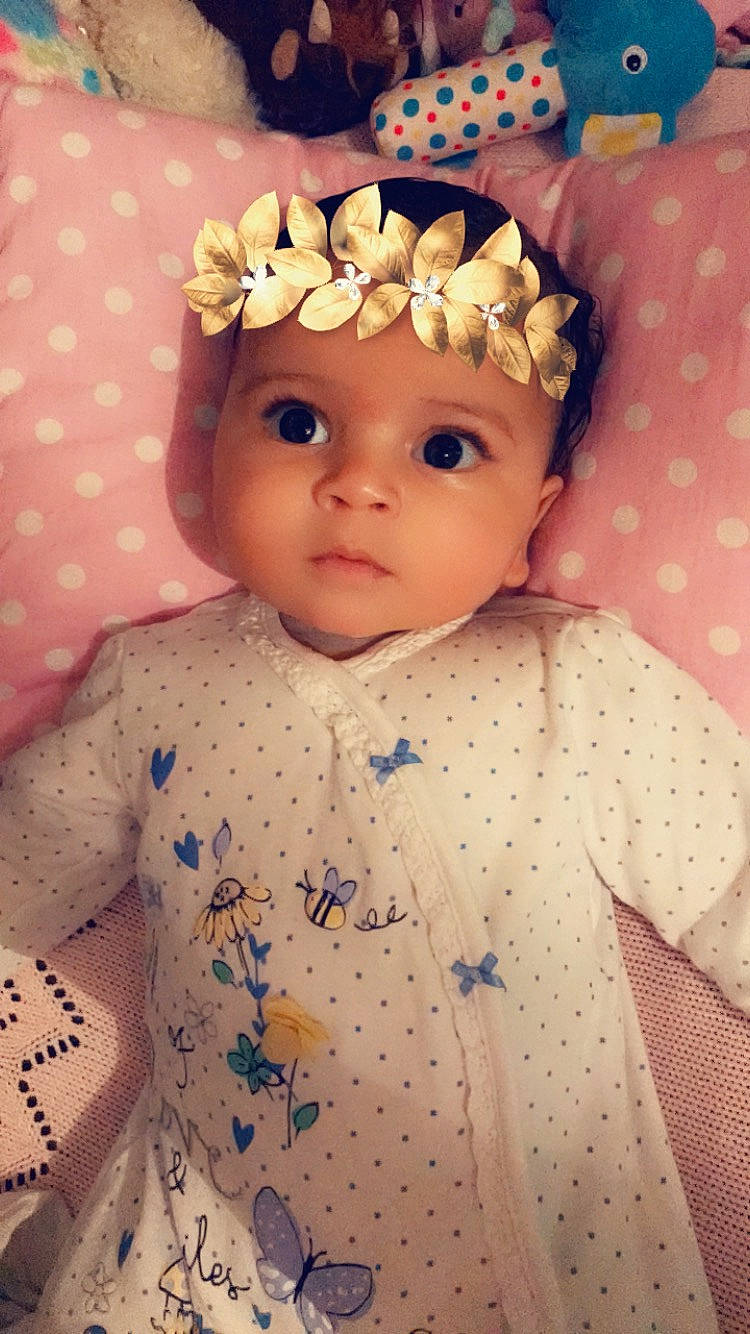 Mika is registered to the contest to win money with this photo: cheek, child, doll, eye, girl, hair_accessory, head, headwear, human_hair_color, infant, iris, nose, person, pink, product, skin, textile, toddler, toy