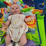 Athena joined the competition — help win amazing prizes! baby, infant, play_mat, colorful, toy, onesie, socks, animal_print, jungle_theme, child, cute, soft_toys, musical_toys, indoor, floor, playtime, smiling_face, young_child, person, lying_down