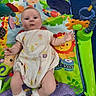 animal_print, baby, child, colorful, cute, floor, indoor, infant, jungle_theme, lying_down, musical_toys, onesie, person, play_mat, playtime, smiling_face, socks, soft_toys, toy, young_child