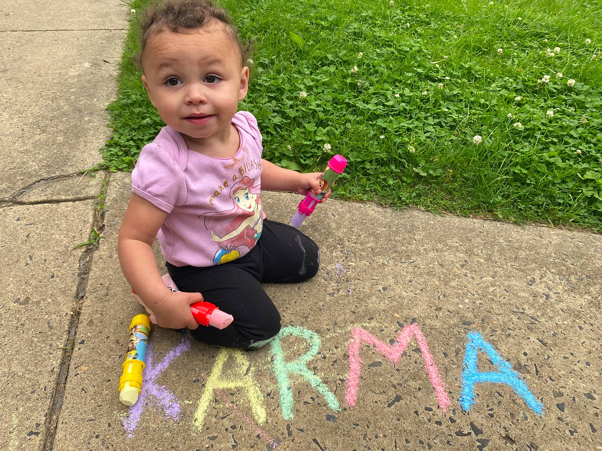 Karma is registered to the contest to win money with this photo: asphalt, baby, baby_toddler_clothing, child, fun, grass, grass_family, handwriting, human_settlement, leaf, leisure, nature, people_in_nature, person, pink, play, public_space, road_surface, spring, summer