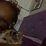person, cat, kitten, calico, bed, headboard, purple, indoor, closeup, snuggling, sleepy, face, hair, eyebrow, framed_picture, wall, cuddling, pet, cozy, relaxing