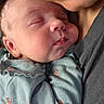 newborn, baby, sleeping, infant, face, portrait, close_up, cuddling, parent, adult, peaceful, eyes_closed, cheeks, nose, mouth, clothing, onesie, floral_pattern, holding, indoor