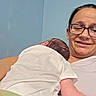Zoey joined the competition — help win amazing prizes! newborn, baby, infant, parent, mother, adult, portrait, selfie, smiling, sleeping, cradling, holding, white_clothing, green_blanket, eyeglasses, nose_ring, hospital_room, seated, indoor, family