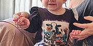 Kinsley is registered to the contest to win money with this photo: toddler, child, smiling, cow_print, clothing, sitting, indoor, person, hands, sofa, blanket, happy, cute, portrait, baby, face, head, adult, holding_hands, cozy