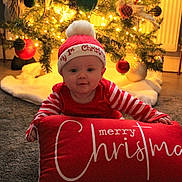 Austin joined the competition — help win amazing prizes! baby, child, christmas, holiday, festive, red_clothing, striped_sleeves, hat, pom_pom, pillow, merry_christmas, carpet, tree, ornaments, lights, indoor, smiling, cute, celebration, seasonal