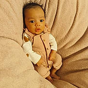 Lya participe au concours pour gagner de l'argent avec cette photo : baby, infant, newborn, pink_overalls, onesie, blanket, soft_texture, cozy, portrait, wide_eyes, curly_hair, skin, hands, toes, seated, bedding, plush, looking_at_camera, cute, indoor