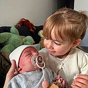 Luna participe au concours pour gagner de l'argent avec cette photo : baby, child, clothing, couch, cute, face, family, girl, hand, headwear, holding, indoor, infant, love, pacifier, plush_toys, sibling, smile, toy, warm