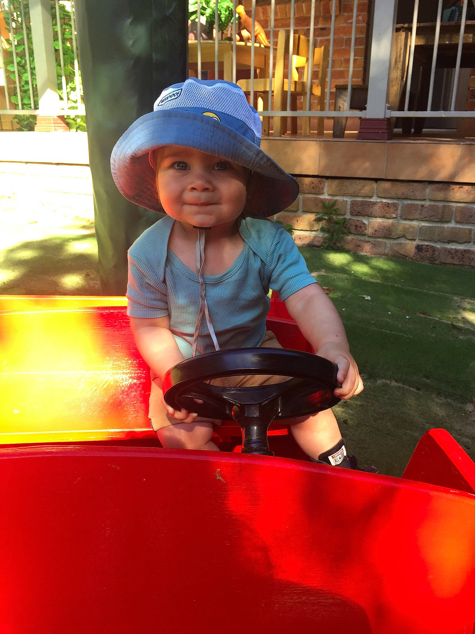 Lincoln is registered to the contest to win money with this photo: automotive_exterior, automotive_tire, baseball_cap, bumper, cap, city, electric_blue, fun, grass, happy, headwear, helmet, joy, leisure, motor_vehicle, person, personal_protective_equipment, recreation, sitting, smile