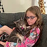 Bella is registered to the contest to win money with this photo: girl, child, cat, tabby_cat, glasses, pajamas, unicorn_pattern, couch, indoor, plush_toy, giraffe_toy, holding, pet, cozy, home, furniture, relaxed, cute, animal, portrait