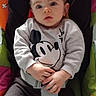 Mathias participe au concours pour gagner de l'argent avec cette photo : baby, child, infant, mickey_mouse, sweatshirt, clothing, seatbelt, car_seat, colorful, expression, face, hands, cute, indoor, portrait, young, person, comfort, sitting, casual