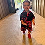 Crixus joined the competition — help win amazing prizes! toddler, child, smiling, walking, red_shoes, black_and_red_outfit, corridor, concrete_floor, shadow, daylight, amazon_hub, happy, shorts, shirt, curly_hair, person, outdoor, sunlight, wall, doorway