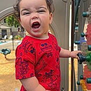 Crixus is registered to the contest to win money with this photo: toddler, child, red_clothing, playground, outdoor, toy, gear, expression, happy, person, summer, daylight, play, fun, plastic, equipment, park, smiling, young_child, casual