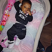 Jae'Onie joined the competition — help win amazing prizes! baby, baby_outfit, bassinet, black_clothing, blanket, child, cute, floor, home, indoor, infant, pacifier, person, pink, purple, relaxing, soft_toy, toy, white, white_shoes