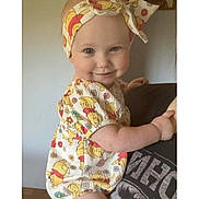 Marley joined the competition — help win amazing prizes! baby, child, headband, smile, person, clothing, arm, hand, tshirt, indoor, wall_art, portrait, cute, infant, holding, colorful, headwear, pattern, happy, skin