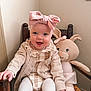 baby, child, pink_bow, knitted_bunny, chair, wooden_chair, smiling, happy, cute, indoors, plush_toy, toddler, cozy, portrait, headband, clothing, knitwear, white_tights, baby_girl, furniture