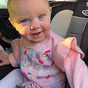 Emma joined the competition — help win amazing prizes! baby, child, car_seat, pink_sweater, blue_eyes, smiling, knitwear, cute, indoor, seatbelt, toddler, happy, portrait, clothing, person, infant, young_child, closeup, sitting, light