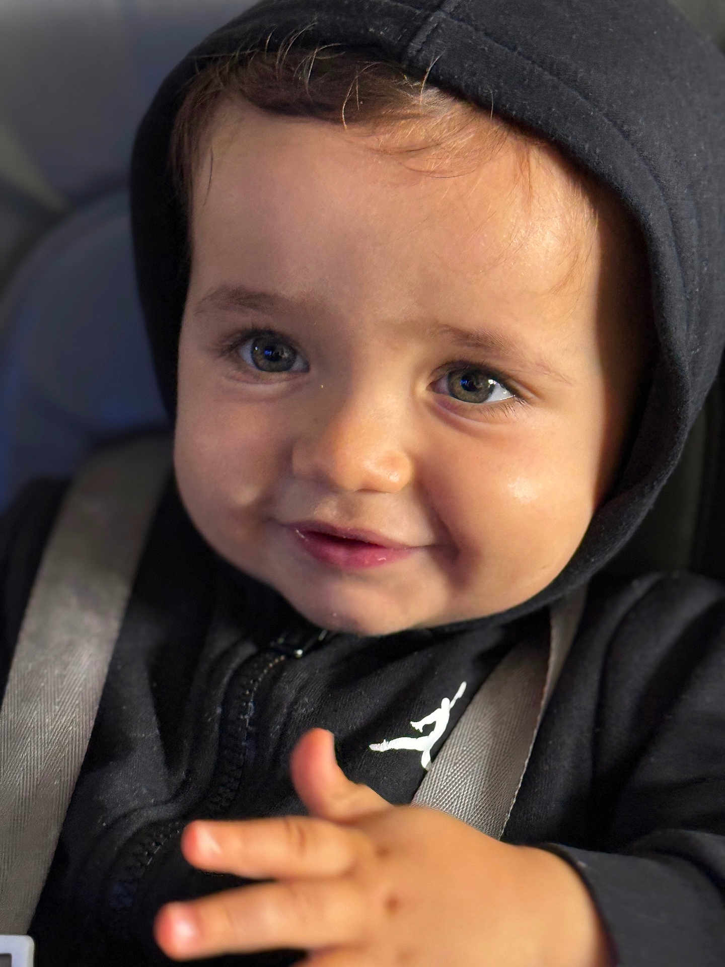 Nahel a rejoint le concours — aidez-le/la à gagner de superbes lots ! child, baby, toddler, face, eyes, smile, hoodie, black_hoodie, closeup, portrait, car_seat, seatbelt, hand, fingers, cheeks, eyelashes, expression, candid, shallow_depth_of_field, soft_lighting
