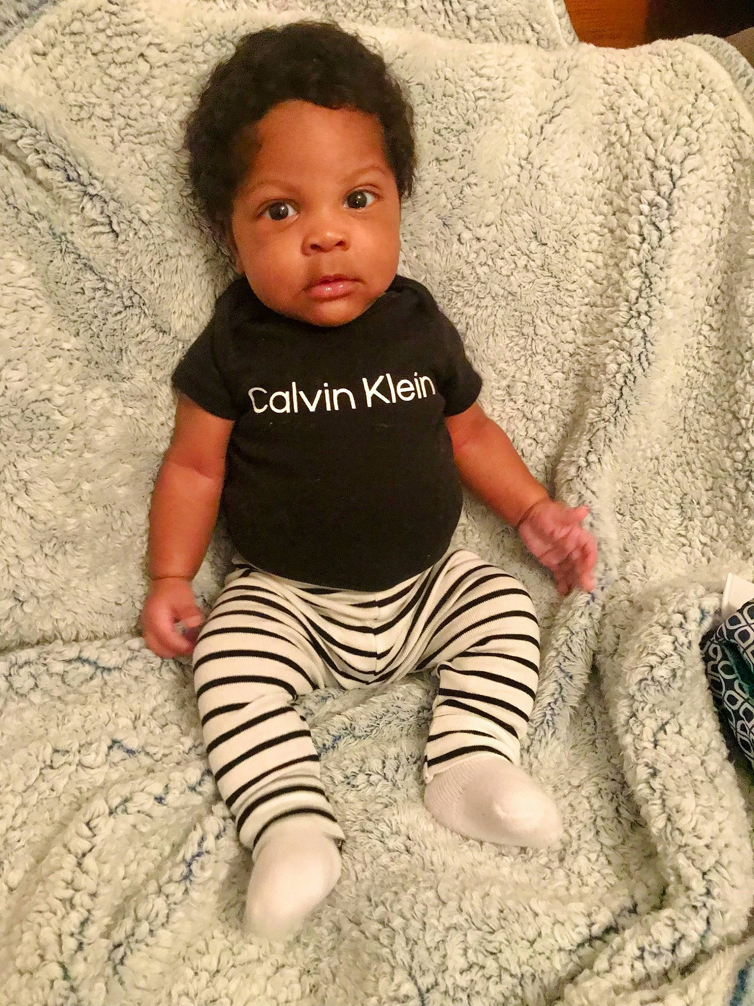 Messiah is registered to the contest to win money with this photo: baby, baby_toddler_clothing, child, comfort, cool, couch, flooring, hairstyle, happy, head, pattern, people_in_nature, person, pillow, sitting, skin, sleeve, standing, t_shirt, toddler