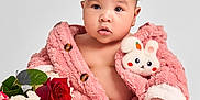 Luna is registered to the contest to win money with this photo: baby, infant, pink_jacket, bunny_patch, flowers, red_roses, white_flowers, greenery, sitting, bare_chest, cute, portrait, studio, soft_lighting, curly_hair, small_feet, expression, child, adorable, fluffy_clothing