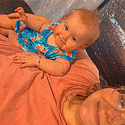 Paisley is registered to the contest to win money with this photo: adult, baby, bed, blanket, bracelet, child, dress, family, floral_dress, glasses, indoor, infant, laying_down, patterned_clothing, pillow, portrait, selfie, smile, smiling, woman