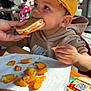 Leyandro a rejoint le concours — aidez-le/la à gagner de superbes lots ! child, toddler, cap, hat, pancake, eating, food, fast_food, restaurant, table, hand, face, hoodie, nike_logo, napkin, potato_pieces, window, highchair, smile, person