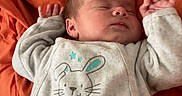 Leo a rejoint le concours — aidez-le/la à gagner de superbes lots ! baby, sleeping, onesie, bunny, infant, blanket, orange, cute, peaceful, child, newborn, soft, clothing, resting, portrait, indoors, small, hands, head, face