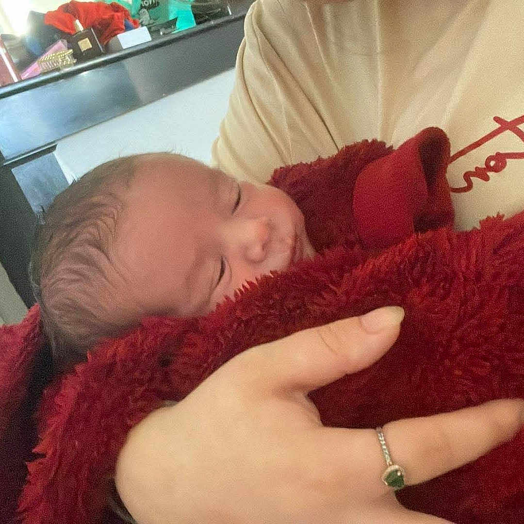 Leo participe au concours pour gagner de l'argent avec cette photo : baby, blanket, hand, indoor, person, sleeping, furniture, dresser, ring, clothing, child, newborn, cozy, soft, peaceful, holding, portrait, relaxation, warm, home