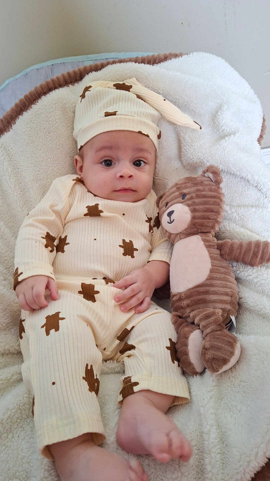 Lonnie joined the competition — help win amazing prizes! baby, infant, toddler, pajamas, hat, stuffed_animal, teddy_bear, blanket, bed, soft_toy, child, cute, indoors, sleepwear, cozy, lying_down, portrait, face, comfort, calm