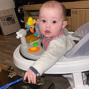 Lina participe au concours pour gagner de l'argent avec cette photo : baby, cabinet, child, clothing, curious, expression, face, floor, furniture, glasses, home, indoor, man, pen, person, table, television, toy, walker, wooden_floor