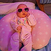 Aryan is registered to the contest to win money with this photo: baby, infant, pink_sunglasses, polka_dot, cushion, blanket, sleepwear, bedroom, soft_lighting, cute, child, relaxed, indoors, person, portrait, sleeping, cozy, comfort, fashion, accessory