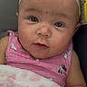 Armani is registered to the contest to win money with this photo: baby, infant, pink_clothing, headband, blanket, face, portrait, person, curious, closeup, child, screenshot, video_player, mobile_screen, soft_texture, candid, indoor, cute, young, wearing