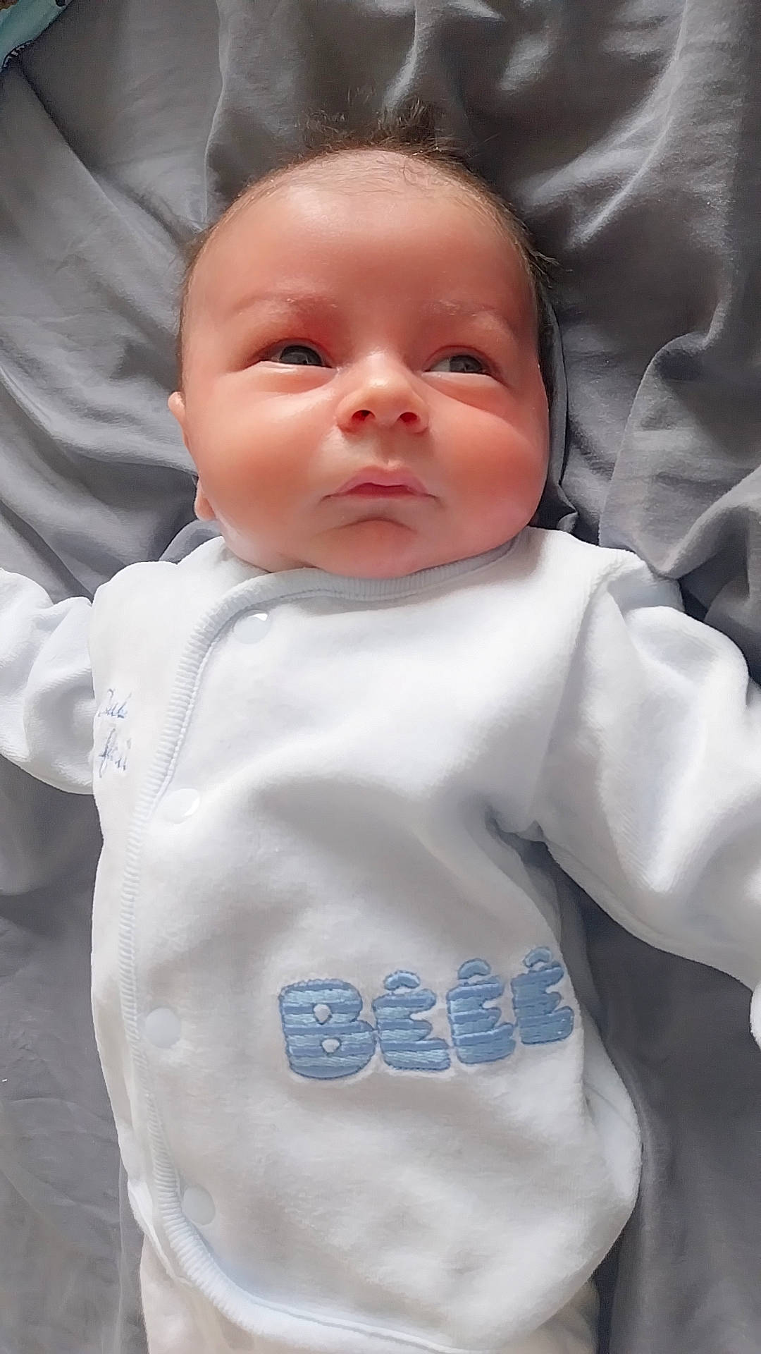 Tiago a rejoint le concours — aidez-le/la à gagner de superbes lots ! baby, bed, blanket, bonnet, clothing, cushion, face, frown, furniture, head, homedecor, longsleeve, newborn, pants, person, photography, portrait, sad, shirt, sleeve