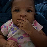Miyonna joined the competition — help win amazing prizes! baby, blue_blanket, child, closeup, curly_hair, cute, expression, face, fingers_in_mouth, hand, heart_pattern, indoors, infant, onesie, patterned_clothing, person, portrait, sitting, skin, young