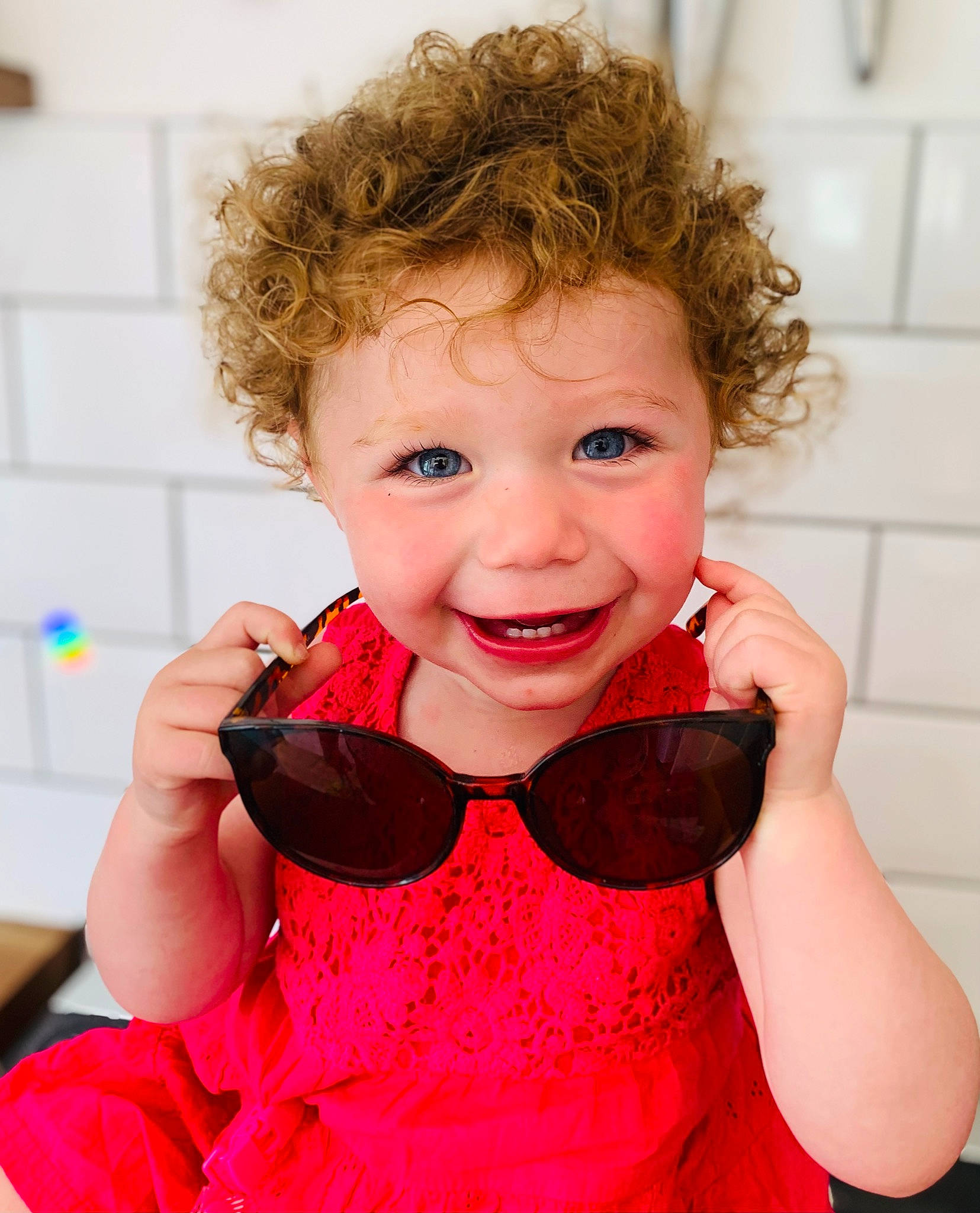 Darcie joined the competition — help win amazing prizes! baby, baby_toddler_clothing, dress, eyelash, face, finger, gesture, goggles, happy, lip, mouth, neck, person, pink, shoulder, skin, sleeve, smile, standing, toddler
