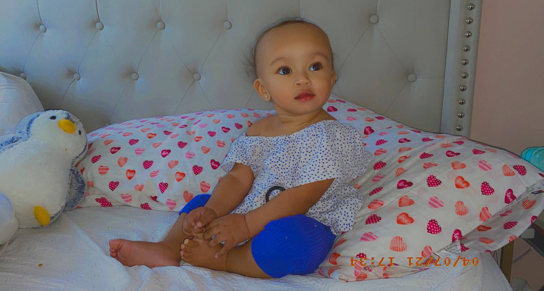 Jayanna is registered to the contest to win money with this photo: arm, baby_toddler_clothing, bed_sheet, bedding, child, comfort, door, foot, human_leg, knee, lap, linens, pattern, person, pink, room, sitting, skin, sleeve, thigh