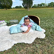 Ava joined the competition — help win amazing prizes! baby, child, outdoor, grass, sky, clouds, pillow, rug, basket, flower, smiling, happy, nature, portrait, infant, greenery, daylight, cute, playful, headband