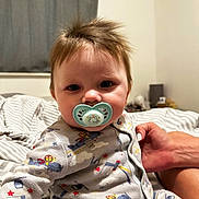 Lucas joined the competition — help win amazing prizes! baby, pacifier, pajamas, bed, hand, person, indoor, child, sleepwear, cute, face, hair, furniture, room, comfort, sleep, expression, holding, blanket, wall