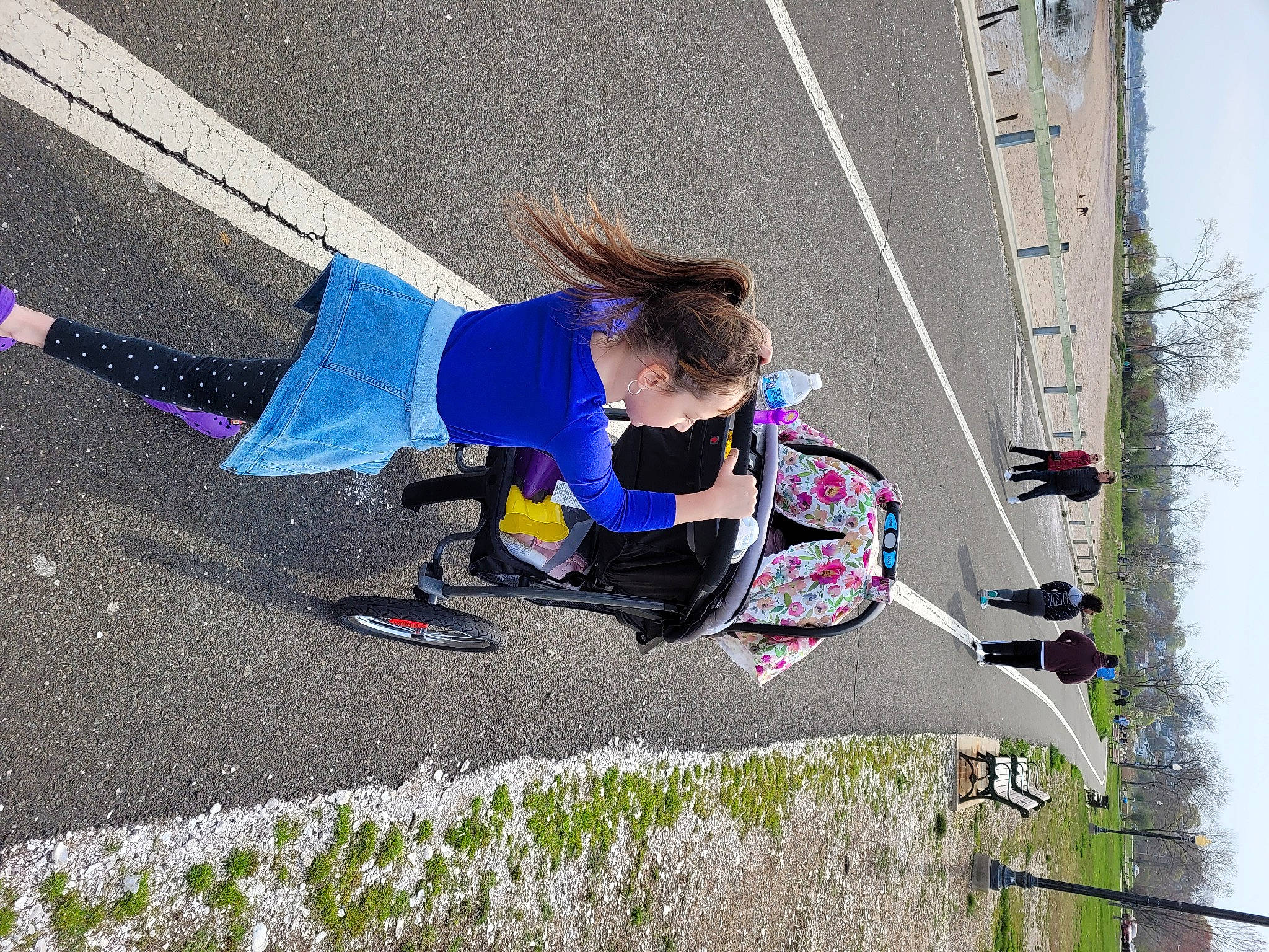 Rylinn is registered to the contest to win money with this photo: asphalt, automotive_wheel_system, cycling, electric_blue, extreme_sport, fun, grass, leisure, pedestrian, person, play, recreation, road, road_surface, shadow, sidewalk, slope, sports, tar, toddler