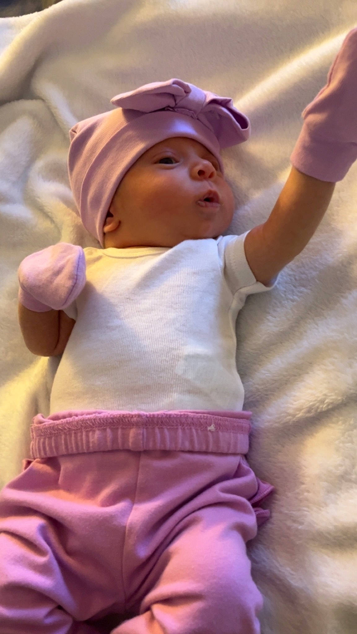 Luella is registered to the contest to win money with this photo: arm, baby, baby_toddler_clothing, cap, clothing, cool, facial_expression, finger, gesture, hand, happy, headgear, headwear, human_body, person, pink, purple, skin, sleeve, sun_hat