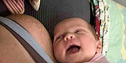 Estella is registered to the contest to win money with this photo: baby, infant, person, skin, clothing, pink_shirt, arm, adult, blanket, fabric, couch, indoor, snuggling, happy, laughing, closeup, head, face, comfort, resting