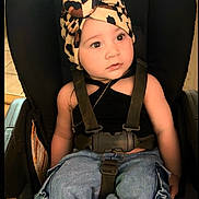 Kiari Chanel is registered to the contest to win money with this photo: child, toddler, baby, car_seat, sitting, portrait, face, eyes, looking_up, curious, cow_print, hat, shoes, jeans, cargo_pants, seatbelt, indoors, vehicle, fashion, smiling