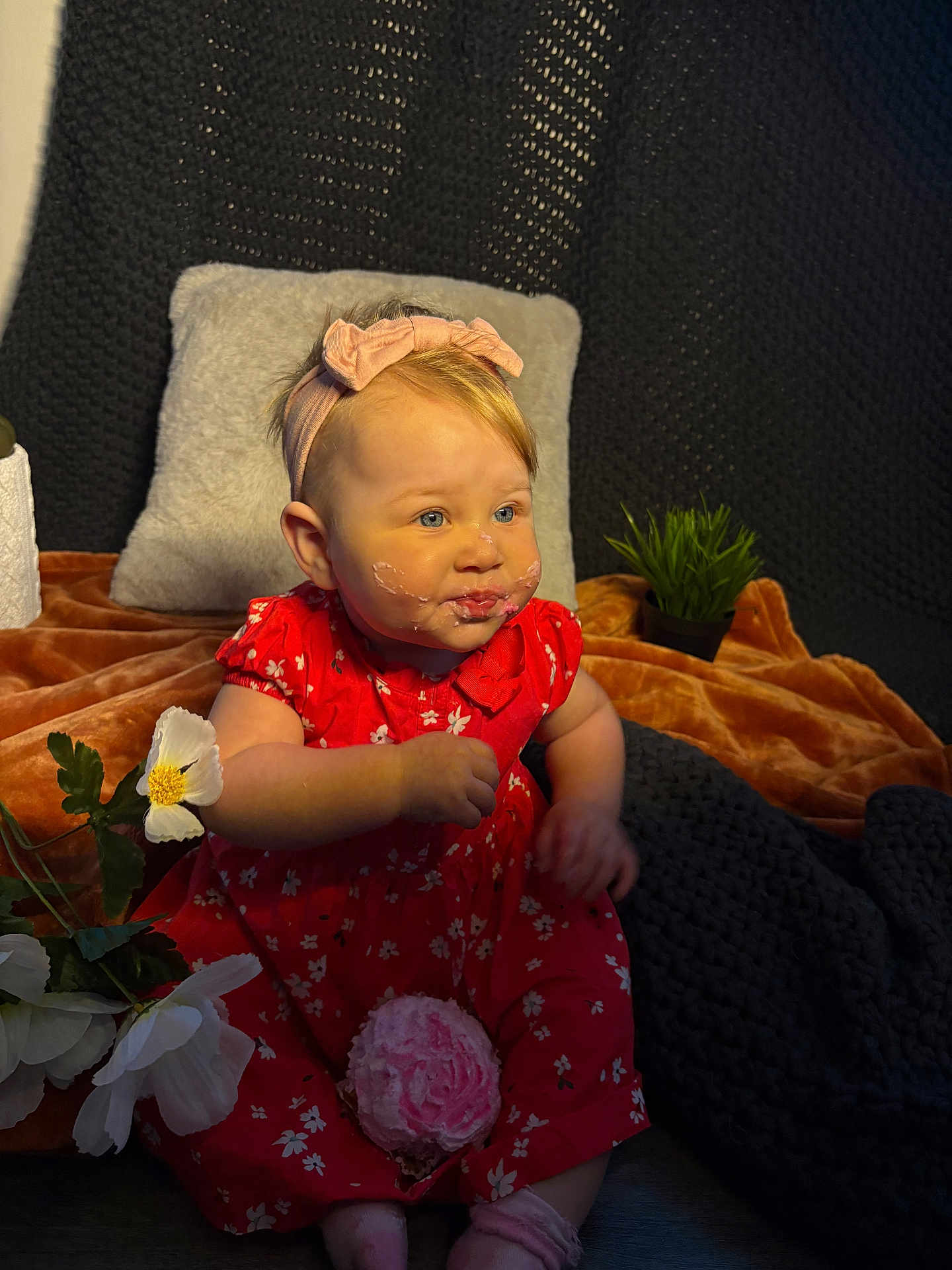 Navayla joined the competition — help win amazing prizes! baby, blanket, child, cozy, cupcake, cute, face, flower, frosting, girl, hands, headband, indoor, pillow, plant, portrait, red_dress, sitting, smile, sock