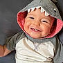 baby, child, smiling, hoodie, shark_hood, teeth, couch, gray, clothing, infant, cute, happy, portrait, sitting, indoors, face, apparel, young_child, playful, casual