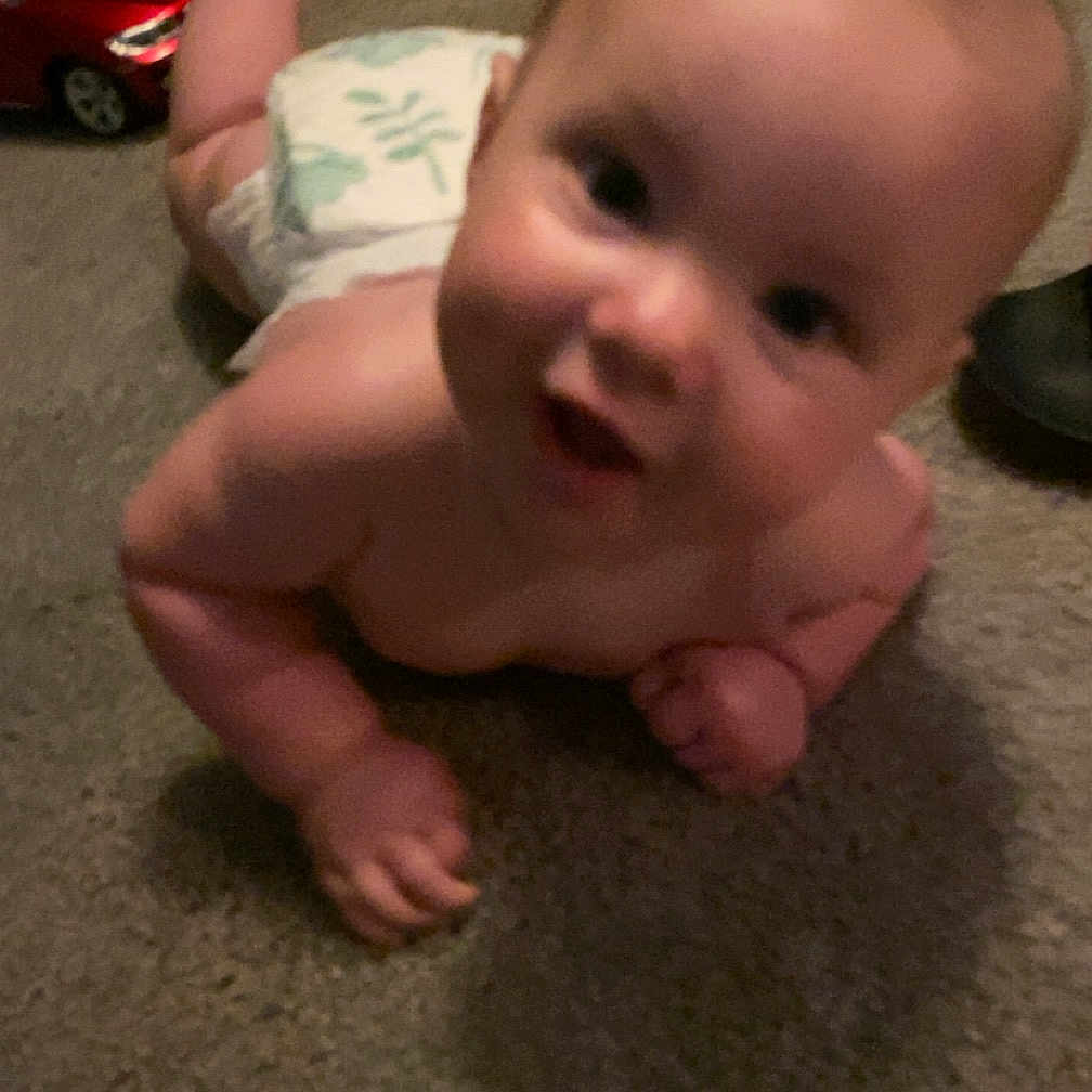 Niklaus is registered to the contest to win money with this photo: baby, bodypart, car, crawling, diaper, face, finger, hand, happy, head, laughing, machine, newborn, person, photography, portrait, sitting, transportation, vehicle, wheel