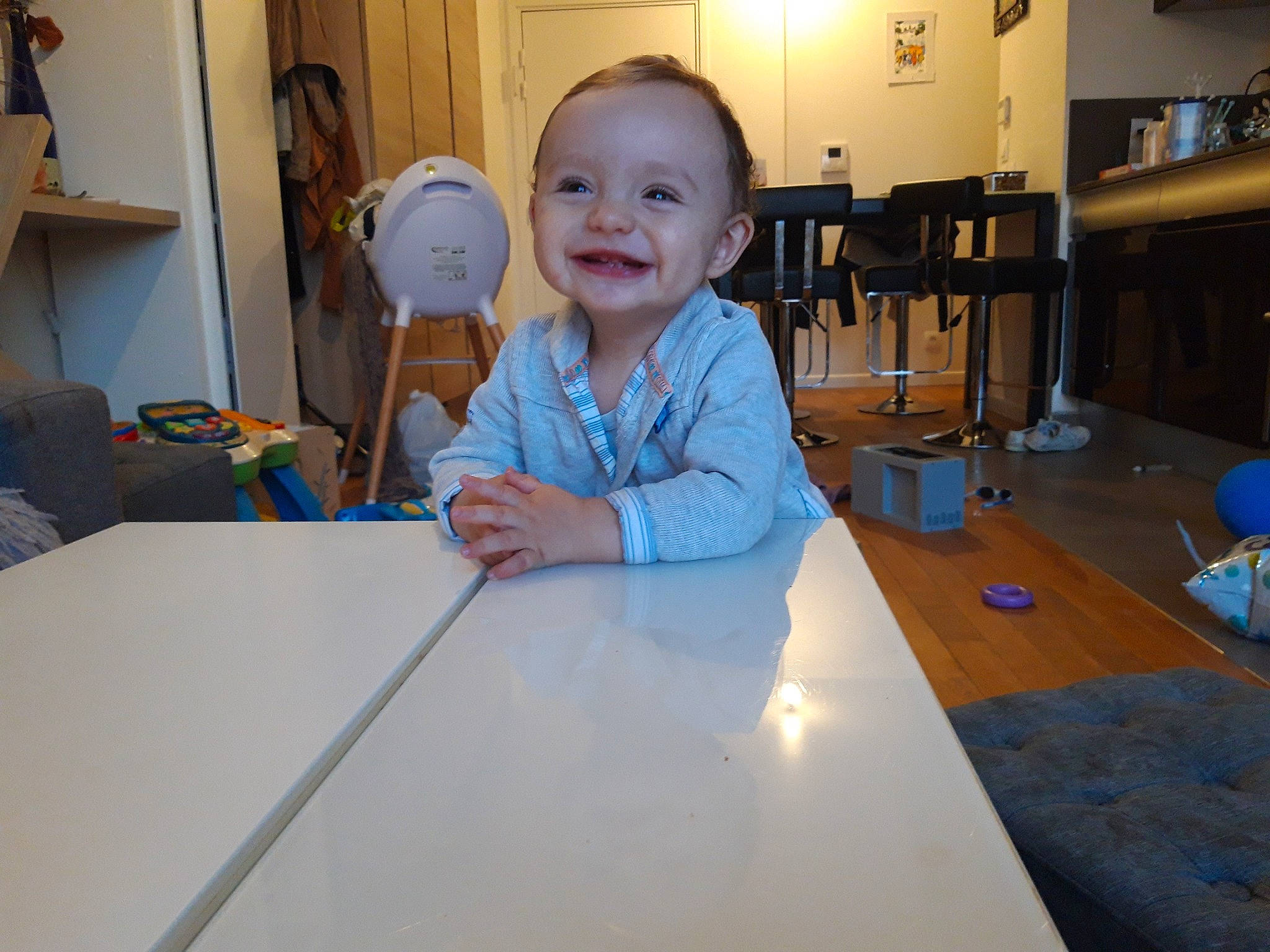 Noah a rejoint le concours — aidez-le/la à gagner de superbes lots ! baby, baby_toddler_clothing, chair, child, event, flooring, fun, furniture, happy, hardwood, joy, leisure, person, play, sitting, smile, t_shirt, table, thumb, toddler