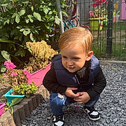 Liam a rejoint le concours — aidez-le/la à gagner de superbes lots ! child, boy, outdoor, garden, flowers, gravel, sneakers, vest, jeans, greenery, fence, butterfly, plants, daylight, cute, casual_clothing, nature, small_child, playful, sunlight