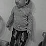 Liam participe au concours pour gagner de l'argent avec cette photo : toddler, child, sweater, jeans, ripped_jeans, sneakers, indoor, floor, wall, toy, gaming_controller, black_and_white, person, standing, casual_clothing, hair, cute, young_child, footwear, home