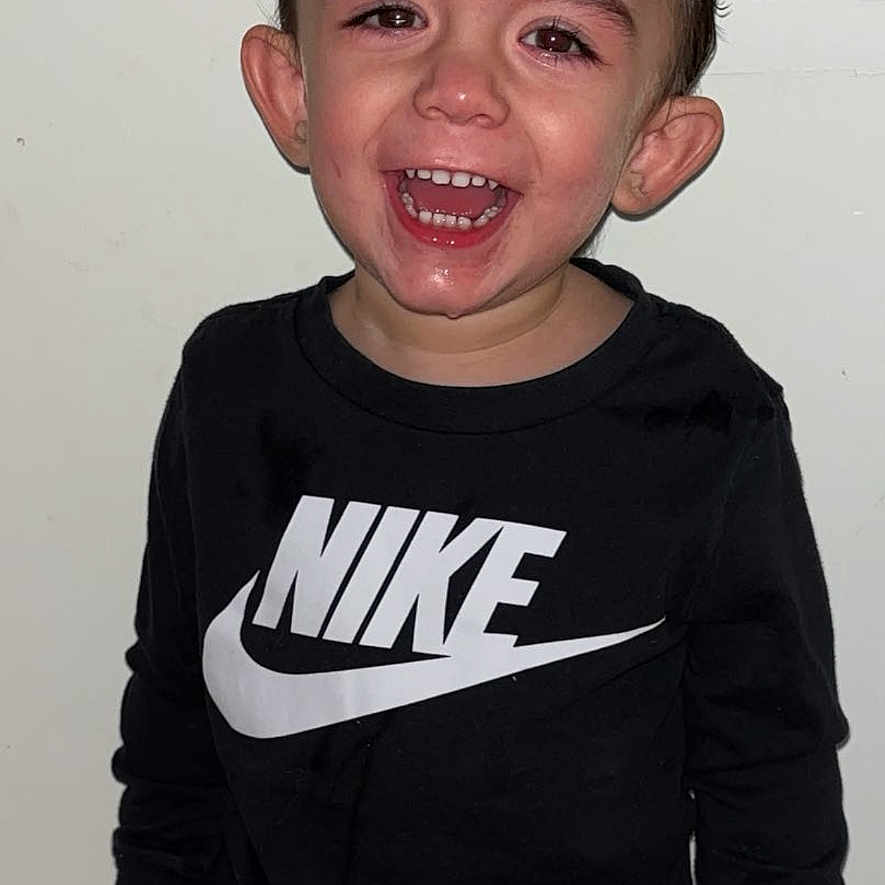 Kingsley a rejoint le concours — aidez-le/la à gagner de superbes lots ! child, toddler, smiling, nike, black_clothing, standing, indoors, happy, portrait, person, casual_wear, young_child, short_hair, front_view, expression, cute, joyful, boy, fashion, door